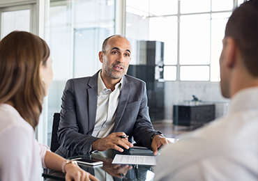 An advisor speaking to clients inside an office